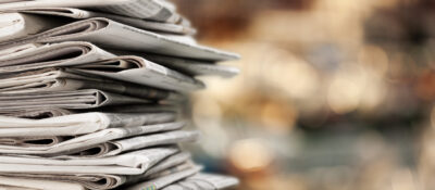 Pile,of,newspapers,stacks,on,blur,background